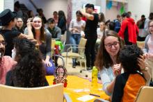 Smiling students paint one another's faces in Day of the Dead style